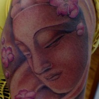 Stone buddha in flowers arm tattoo