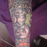 Evil hindu spirit coloured arm tattoo
