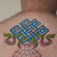 Buddhist symbol with lotus coloured tattoo