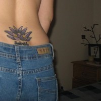 Le tatouage de lotus pourpre sur le bas du dos