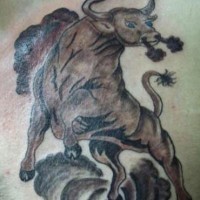 Running angry bull in dust tattoo