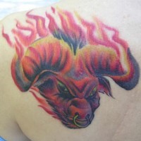 Le tatouage coloré de taureau diabolique en flammes