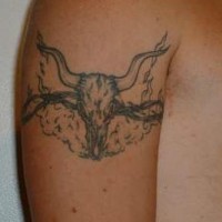 Le tatouage-brassard de la crâne de taureau avec un fil de fer barbelé