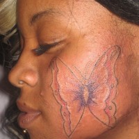 Butterfly tattoo on cheek