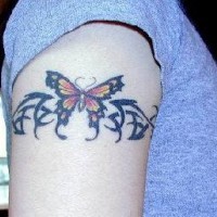 Tatuaje de un brazalete con una mariposa tribal.