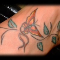 Le tatouage de papillon doré avec des feuilles sur le pied