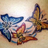 Le tatouage de trois papillons avec des hiéroglyphes colorés