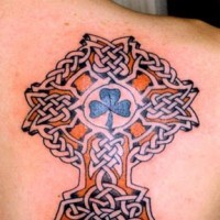 Tatuaje trébol dentro de la cruz celta en el hombro