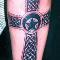 Le tatouage d'étoile dans le croix celtique sur la jambe
