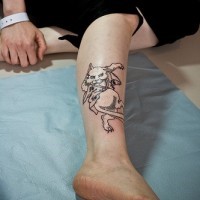 Dancing white cat tattoo on leg