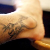 El tatuaje realista de una lagartija pequeña en color negro en la pierna