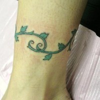 Baum-Tattoo mit grüner Rebe um das Bein