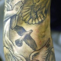Praying cherub with doves tattoo on sleeve