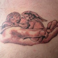 Sleeping cherub in hand tattoo