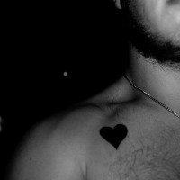 Tattoo von schwarzem Herzen auf der Brust