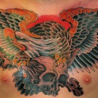 Bird carrying a skull chest tattoo