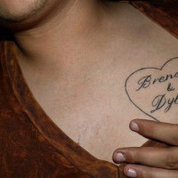 Names in heart chest tattoo