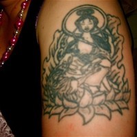 Chinesische Frau sitzt auf Lotus Tattoo