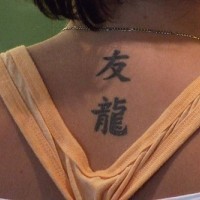 Chinese charachters tattoo on lower neck