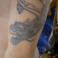 tatuaje en el brazo en tinta negra de dragón chino