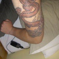drago cinese largo sul braccio tatuaggio
