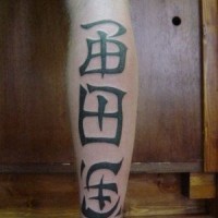 Le tatouage de gros hiéroglyphes  sur la jambe