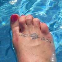 Le tatouage de petit trèfle à quatre feuilles sur le pied