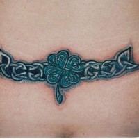 tatuaje en la parte baja de la espalda de tracería céltica con trébol de cuatro hojas