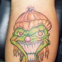Green smiling clown leg tattoo