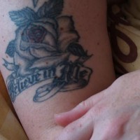 Black rose and writings tattoo
