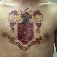 Golden and red heraldic shield tattoo on chest