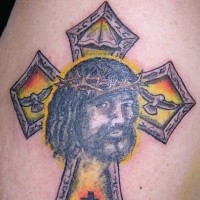 Tatuaggio colorato sul deltoide la croce & il viso del uomo