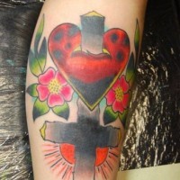Le tatouage de croix renversé avec le cœur et des fleurs en couleur