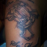 croce con mani di preghiera tatuaggio