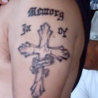 Memorial cross tattoo on arm
