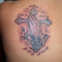 croce con mani di preghiera tatuaggio