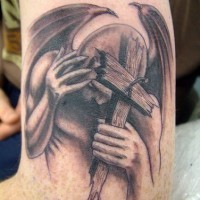 Fallen angel with wooden cross tattoo