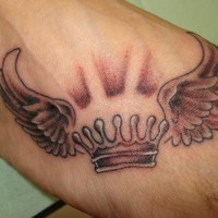 Winged crown arm tattoo