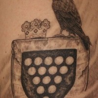 scudo araldico con corvo e corona tatuaggio