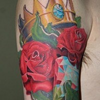 Le tatouage de couronne doré avec le diamant et des roses sur l'épaule