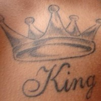 tatuaje en tinta negra de corona con King