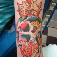 tatuaje colorido de calavera con una rosa en la boca y corona en la cabeza