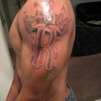 monogramma incoronata tatuaggio sulla spalla