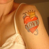 amore sul cuore rosso con corona tatuaggio sulla spalla