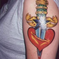 pugnale d'oro accoltellato cuore tatuaggio sulla spalla
