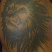 El tatuaje de la cabeza de un leon negro con melena grande en el hombro