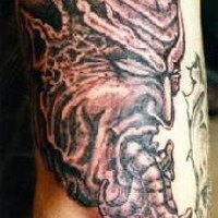 Le tatouage de la tête de démon avec des vers dans sa bouche