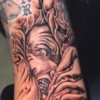 Demon in agony arm tattoo