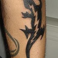 El tatuaje tribal de una lagartija con un rayo en color negro