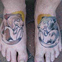 Two coloured dogs tattoo on feet
